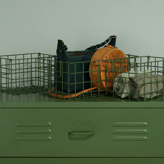 A set of three forest green metal baskets on a set of green metal drawers.